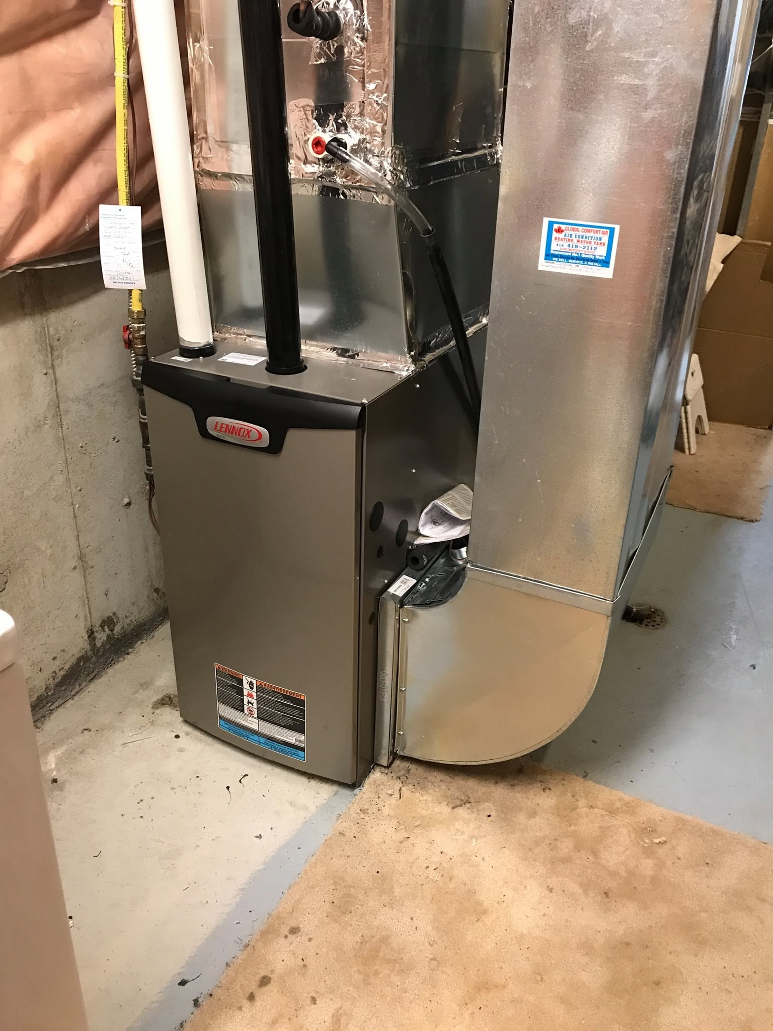 Technician inspecting gas furnace Whitby home